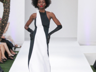Modella con un abito lungo bianco e nero con guanti.