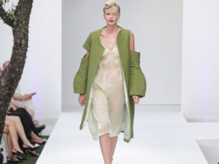 Modella con un abito trasparente e un cappotto verde.