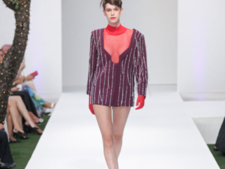 Modella con un completo scintillante bordeaux e guanti rossi.