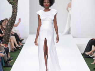 Modella con un abito bianco lungo e drappeggiato.