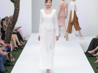 Modella con un abito lungo bianco semplice e catenina.