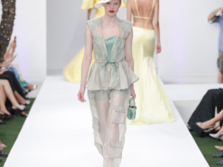 Modella con un completo trasparente, giacca leggera e pantaloni.