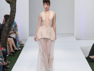 Modella con abito rosa cipria trasparente e ricami dorati.